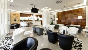 Eine moderne Lobby mit Barbereich, Sitzgelegenheiten und einer Wandverkleidung.