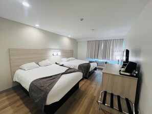 A hotel room with two beds, a desk with a coffee machine, and a chair. - Pinewood Motor Inn (Espanola)
