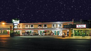 Un motel Pinewood con una tienda 7-Eleven al otro lado de la calle.