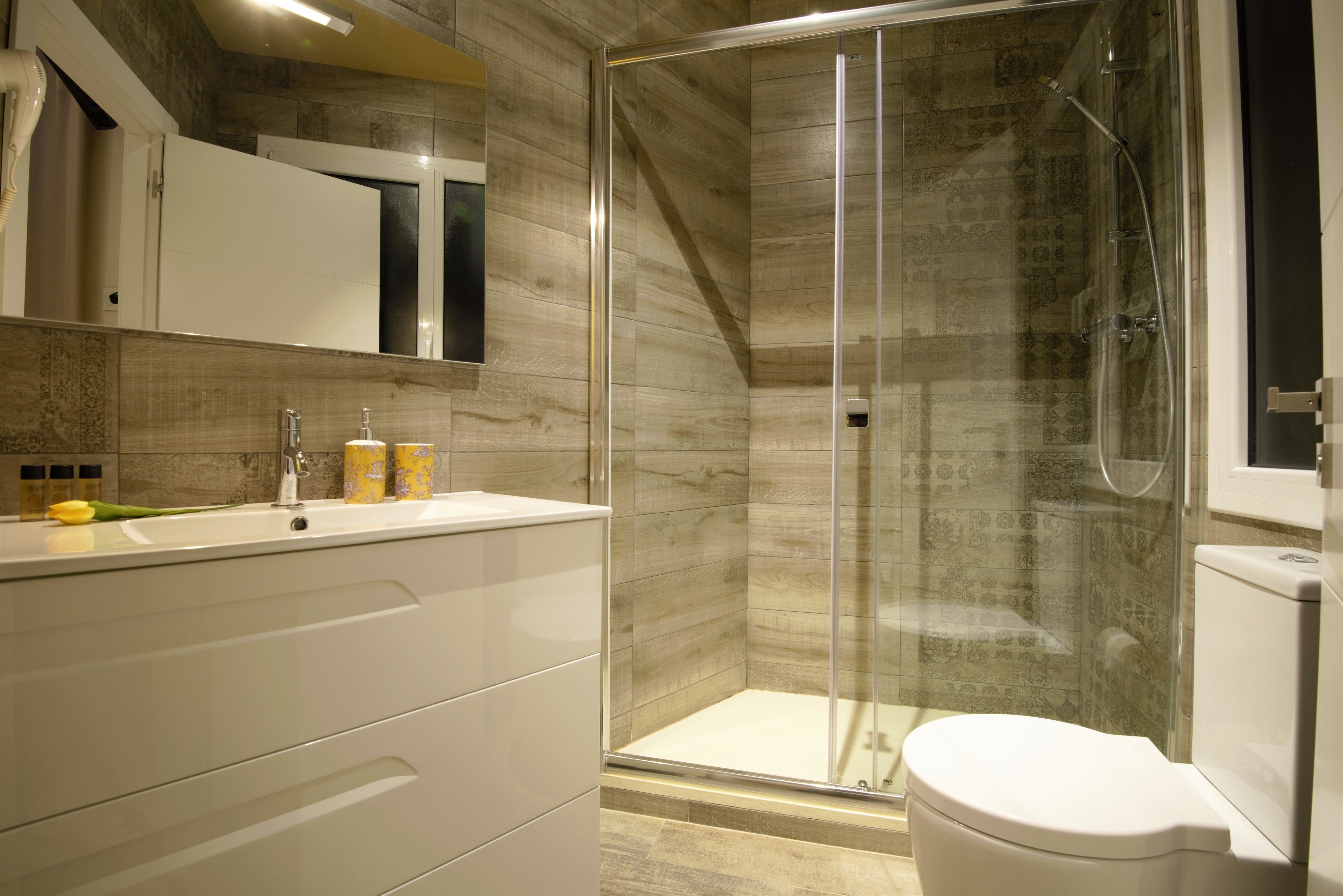 Une salle de bain moderne avec une douche à parois de verre, un lavabo blanc et des toilettes.