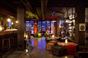 A bar area with stools, a counter, and a view of the cityscape through large windows.