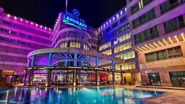 A hotel with a pool area, a prominent Helnan Landmark sign, and a modern architectural design. - Helnan Landmark Hotel (New Cairo)