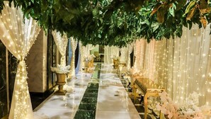 A corridor with a marble floor, draped white curtains, and hanging lights. - Helnan Landmark Hotel (New Cairo)