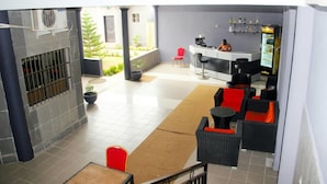 A modern indoor space with a bar area, seating, and a view of the outdoors. - Mint Hotel (Lomé)