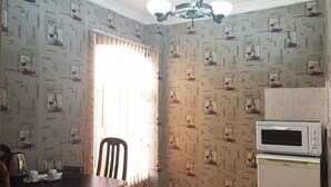 Una pequeña cocina con microondas, una mesa y una silla.
