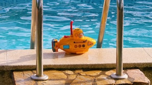 Een zwembad met een gele duikboot speelgoed op de rand.