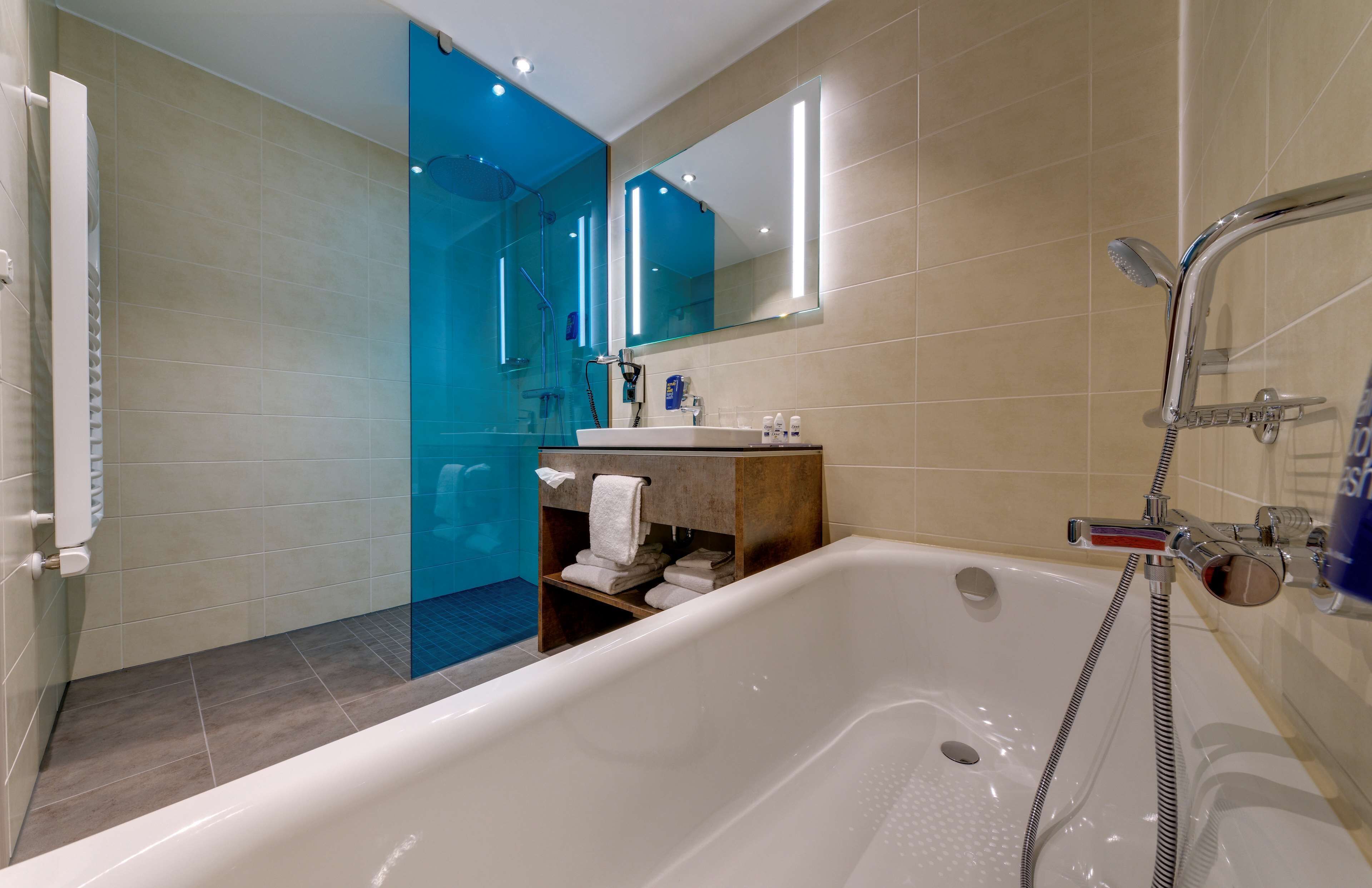 A modern bathroom with a bathtub, shower, and a glass-enclosed shower area.