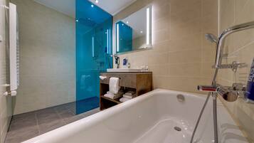 A modern bathroom with a bathtub, shower, and a glass-enclosed shower area.