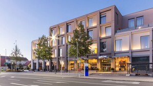 Ein modernes Hotel mit einer glatten Fassade, zahlreichen Fenstern und einem sichtbaren 'Park Inn'-Schild.