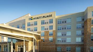 A multi-story building with a stone facade and a sign reading "HYATT PLACE".