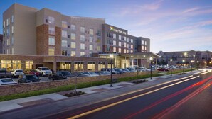 A multi-story hotel with a modern design, featuring a parking lot and a well-lit entrance. - Hyatt Place Lubbock (Lubbock)