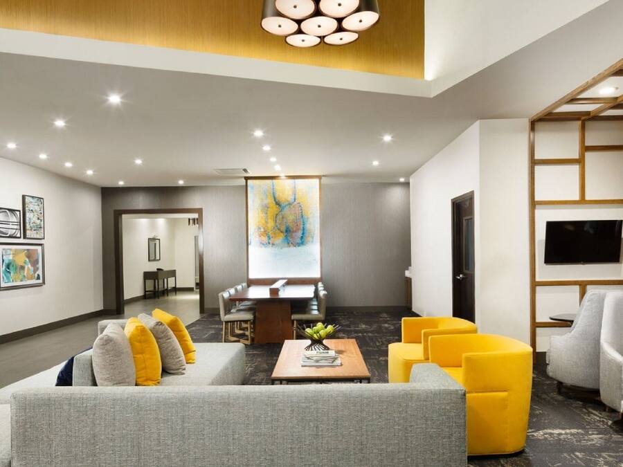 Een moderne hotellobby met een eetgedeelte, banken en kunstwerken aan de muur.