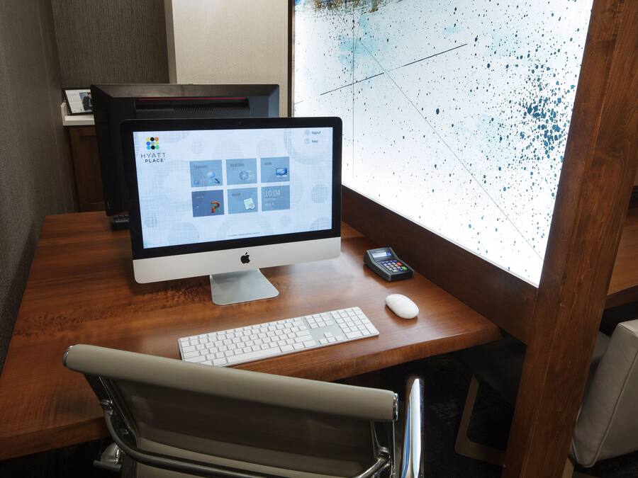 Una computadora de escritorio con monitor, teclado y ratón sobre un escritorio de madera.