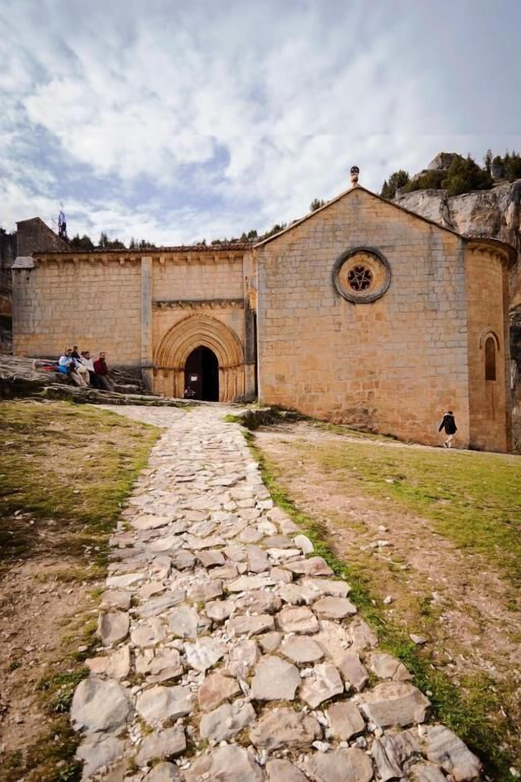 Un bâtiment en pierre doté d’une entrée centrale en forme d’arc et d’une fenêtre circulaire au-dessus.