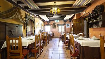 Un restaurant amb caires i taules de fusta, un penjall i un paviment de rajoles.
