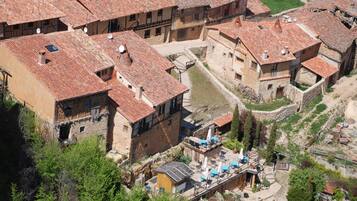 A traditional village with stone buildings and red-tiled roofs.