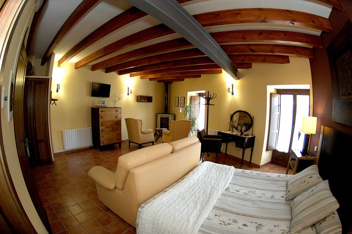 Ein Zimmer mit Bett, Sofa, Schreibtisch und Fernseher.