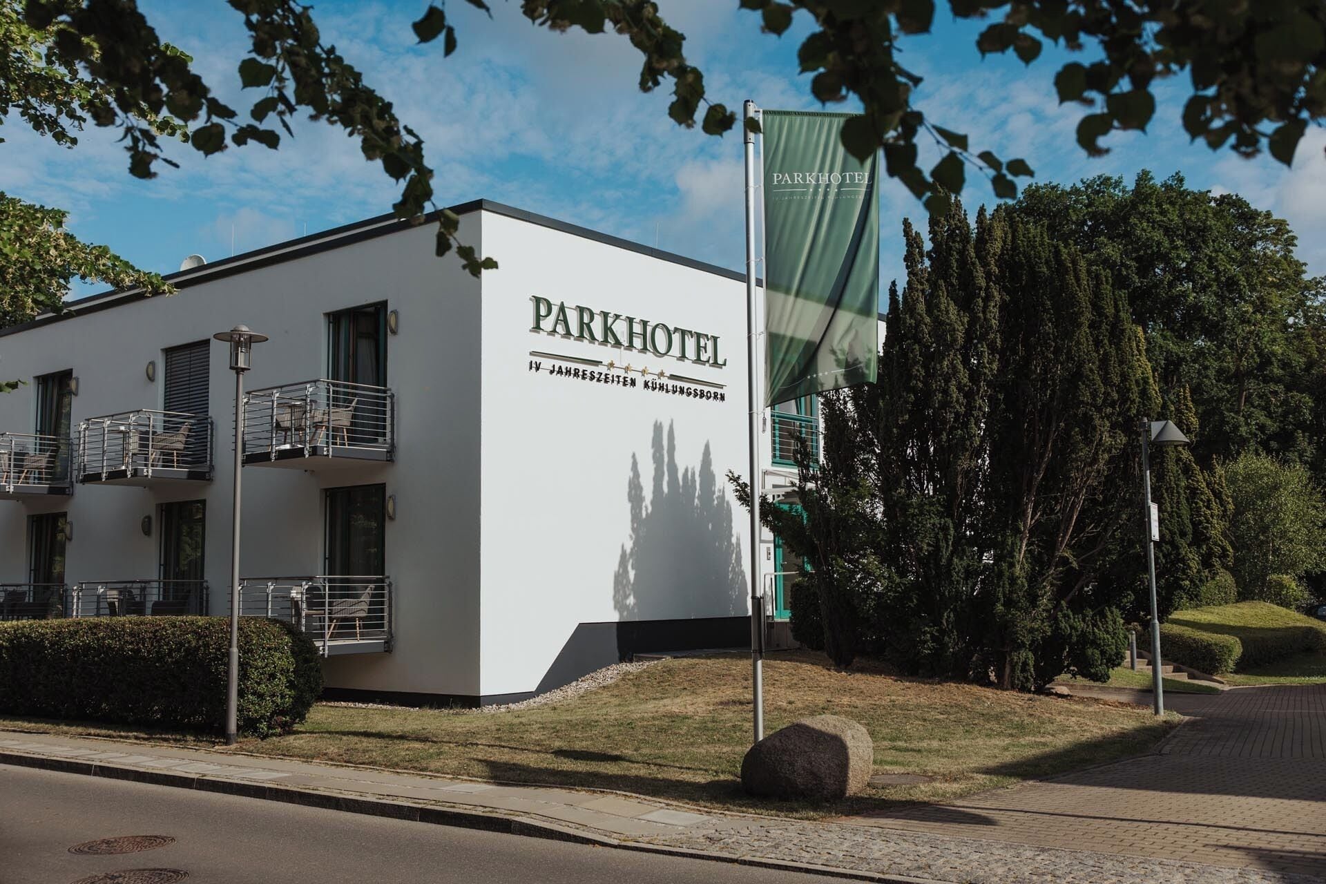 A modern building with a sign reading "Parkhotel IV Jahresthemen Kühlungsborn".