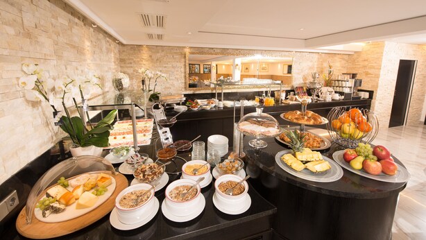 Un bufé con diversas opciones de comida y un área de estar al fondo.