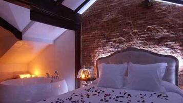 Una camera da letto con un letto grande, un soffitto in legno e un muro in mattoni.