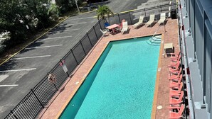 A rectangular pool with a brick deck and a metal railing.