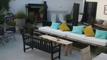 Un espacio al aire libre con patio, sofá, mesa de comedor y sillas.