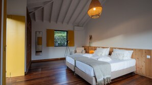 A bedroom with a large bed, two bedside tables, a tripod lamp, and a wooden ceiling. -  Carmo Country Villas (Ponta Delgada)