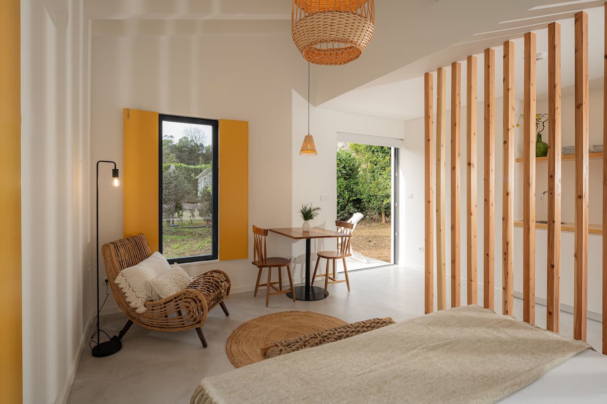 Una habitación moderna con un ventanal grande, zona de comedor y cama.