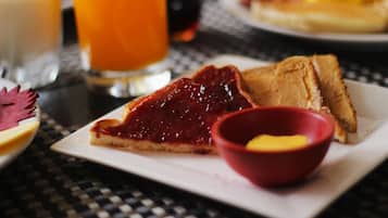 Ein Frühstücksteller mit Toast, Marmelade und einer kleinen Butterportion.
