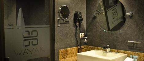 A bathroom with a sink, mirror, and hairdryer.