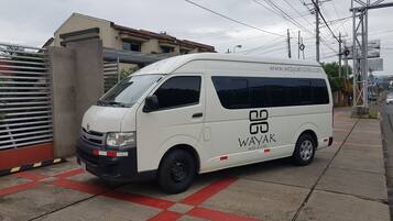 A white van parked on a sidewalk with a logo and website on the side.