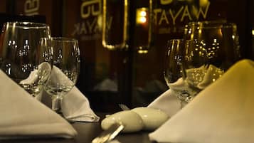 A table set with wine glasses, a bottle, and a white napkin.