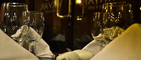 A table set with wine glasses, a bottle, and a white napkin.