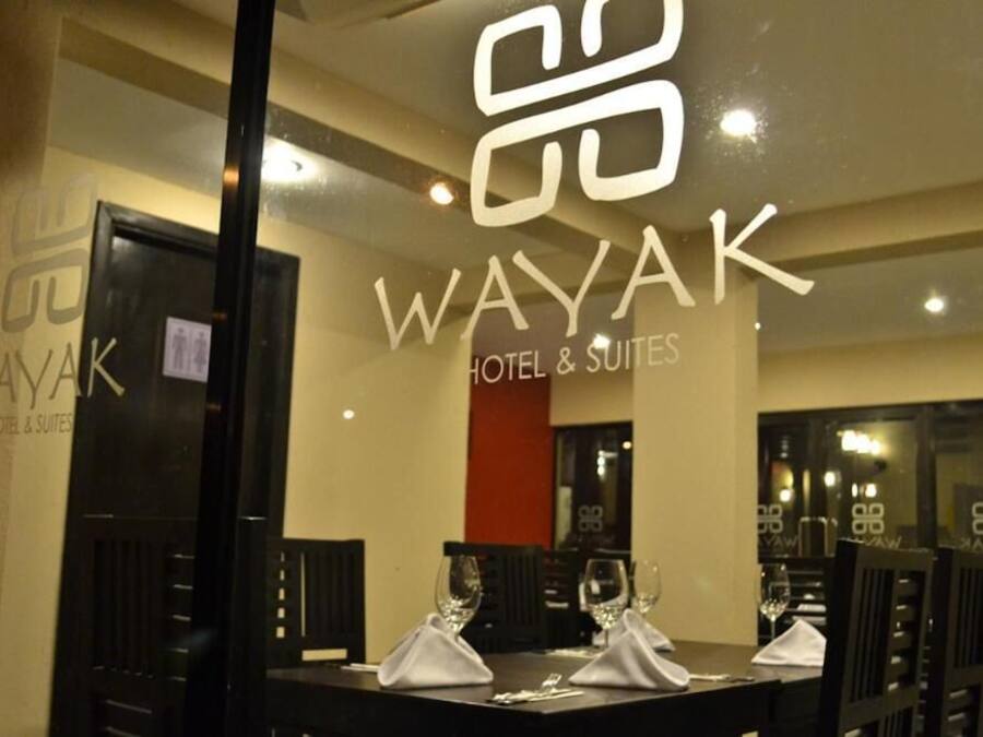 Un restaurante con un muro de cristal que muestra el logotipo del Wayak Hotel & Suites.