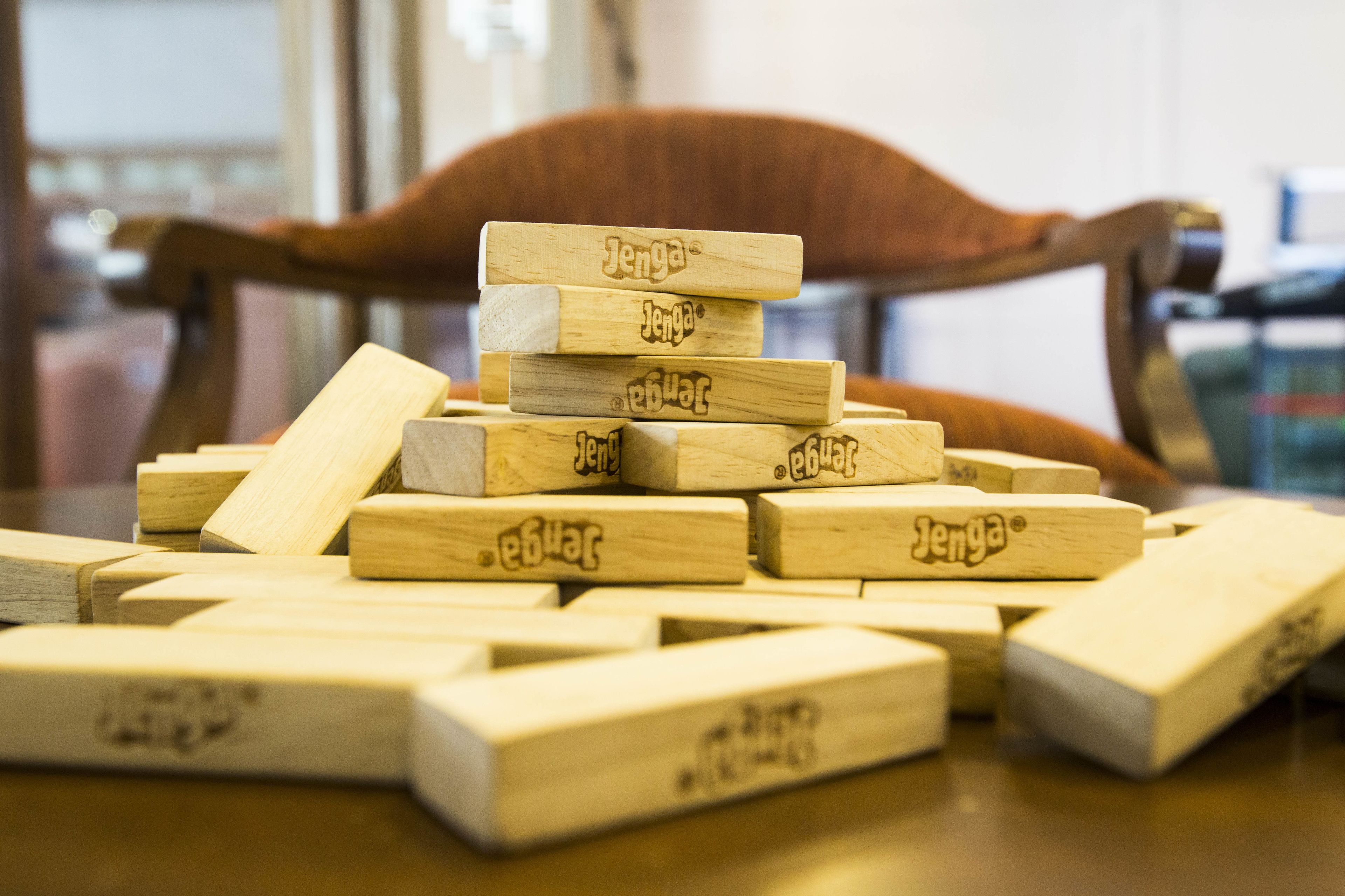 Wooden blocks with the brand name "Jenga" on a table.