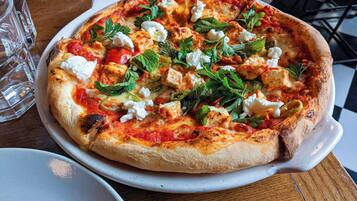 Una pizza con diferentes ingredientes sobre un plato blanco.