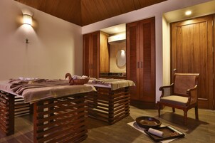 Un dormitorio con cama de madera, una silla, una mesita con toallas y un espejo en la pared.