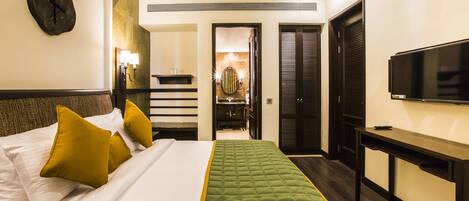 A hotel room with a bed, a television, a desk, and a mirror.
