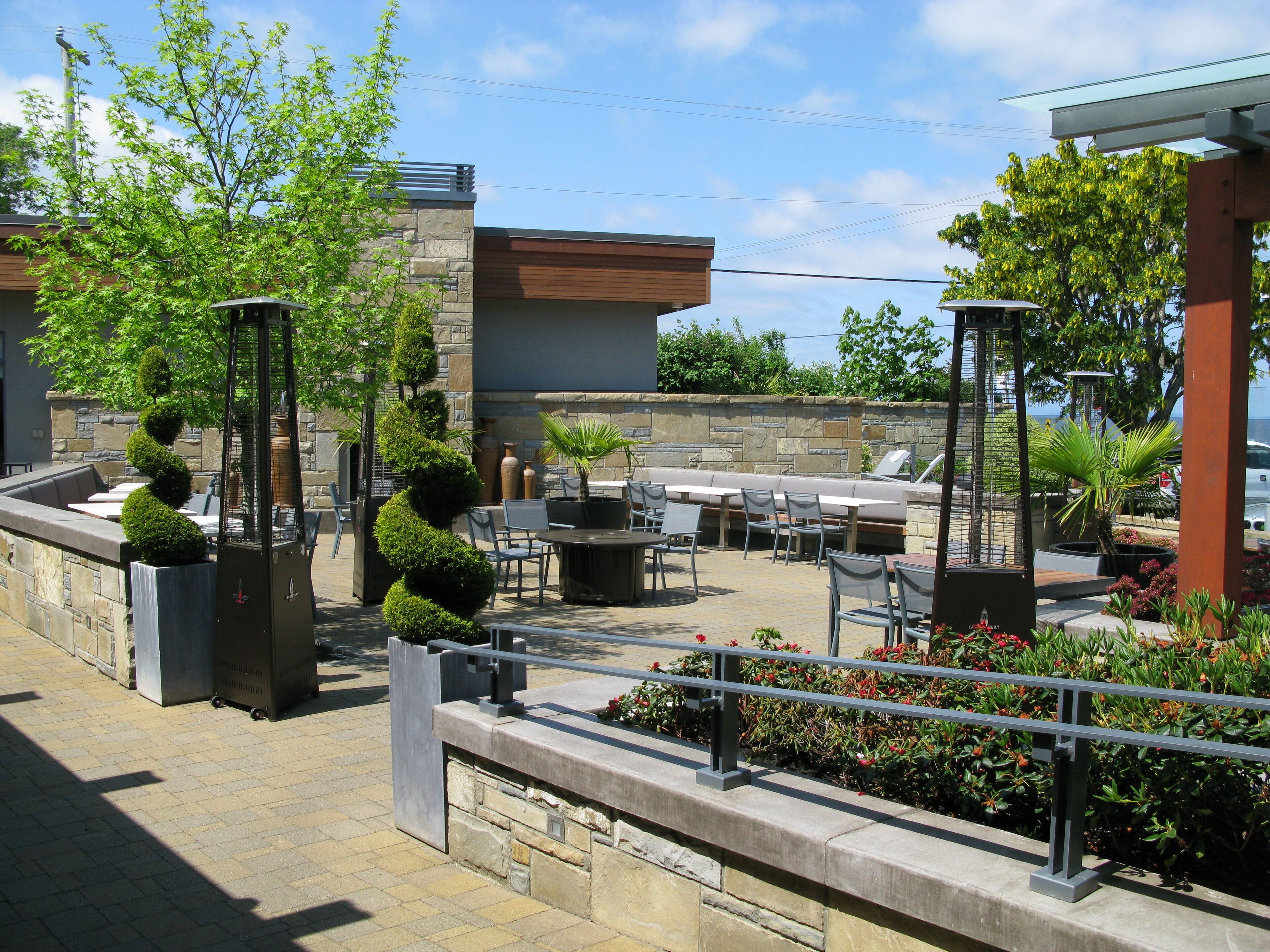 An outdoor patio with stone walls, seating areas, and potted plants.