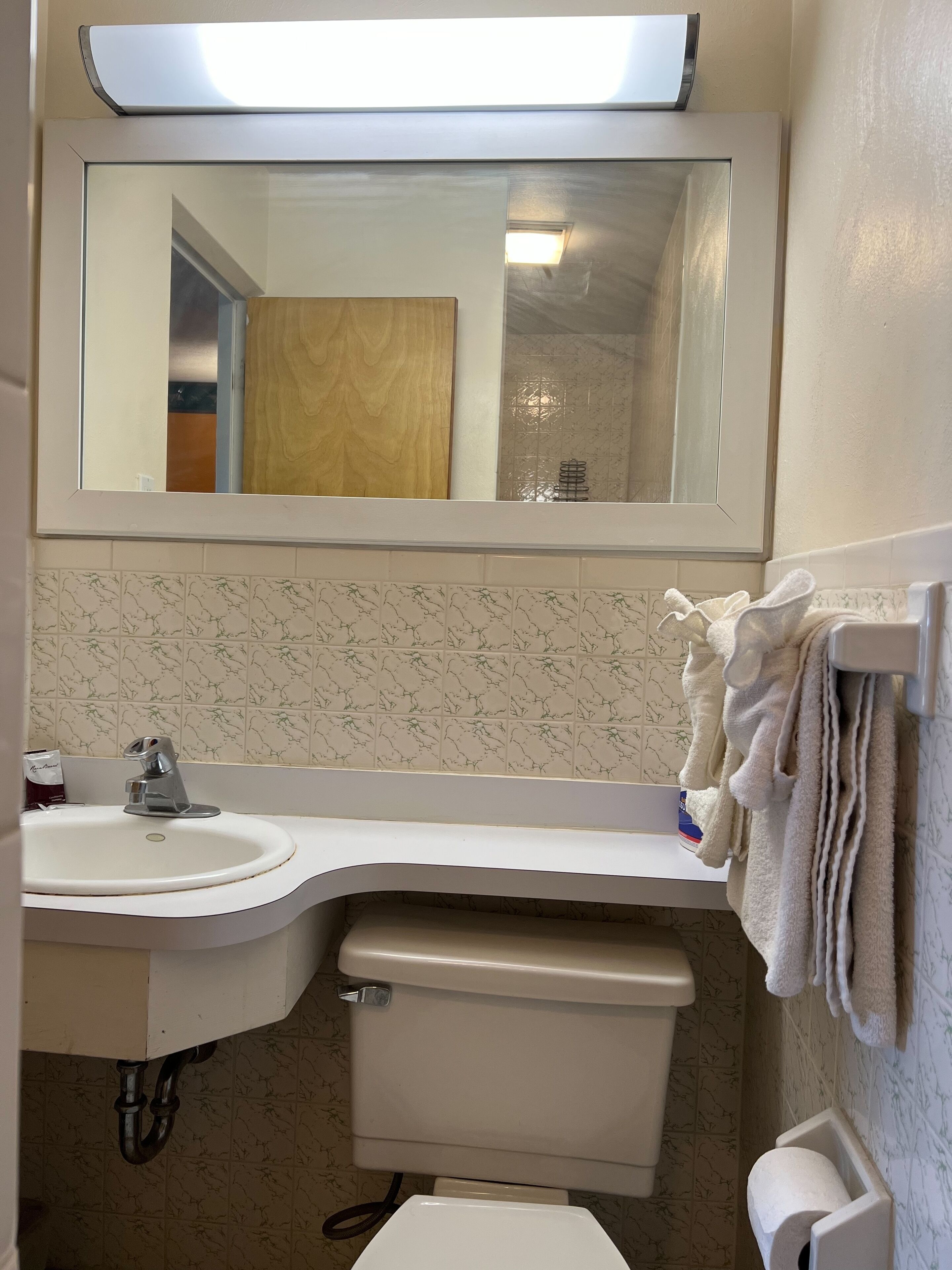 Ein Badezimmer mit Waschbecken, Spiegel und Toilette.