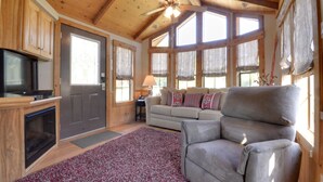 A cozy living room with a fireplace, a sofa, and a television.