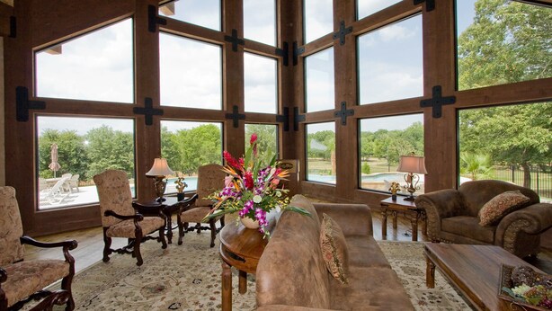 A spacious living room with large windows, a fireplace, and a view of the outdoors.
