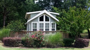 A house with a gabled roof, multiple windows, and a wooden fence.