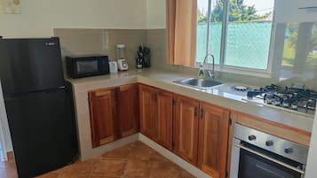 Une cuisine équipée d’un réfrigérateur, d’un four à micro-ondes, d’un grille-pain, d’un évier et d’une cuisinière.