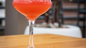 A cocktail in a martini glass on a wooden table.