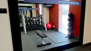 A gym with exercise equipment, a red exercise ball, and a motivational sign. - Hampton Inn Suffolk (Suffolk)