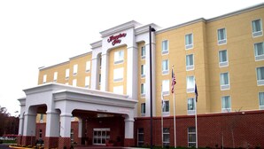A Hampton Inn hotel with a brick facade, multiple windows, and a clear entrance. - Hampton Inn Suffolk (Suffolk)