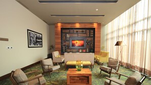 Una sala de estar moderna con televisor, sofás, sillones y una alfombra estampada.