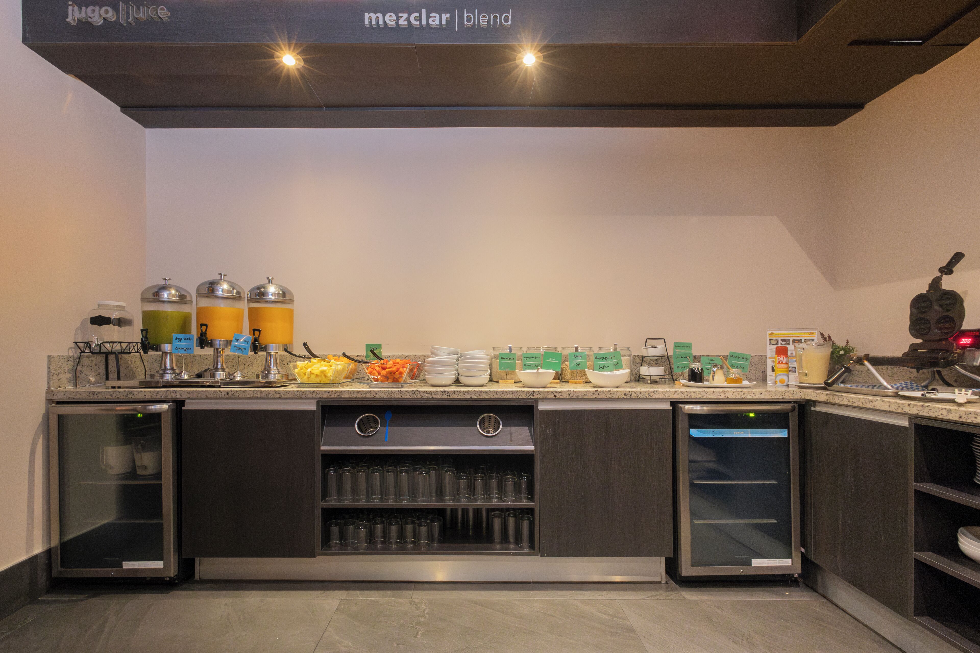 A modern kitchen with a built-in coffee station, a refrigerator, and a microwave.