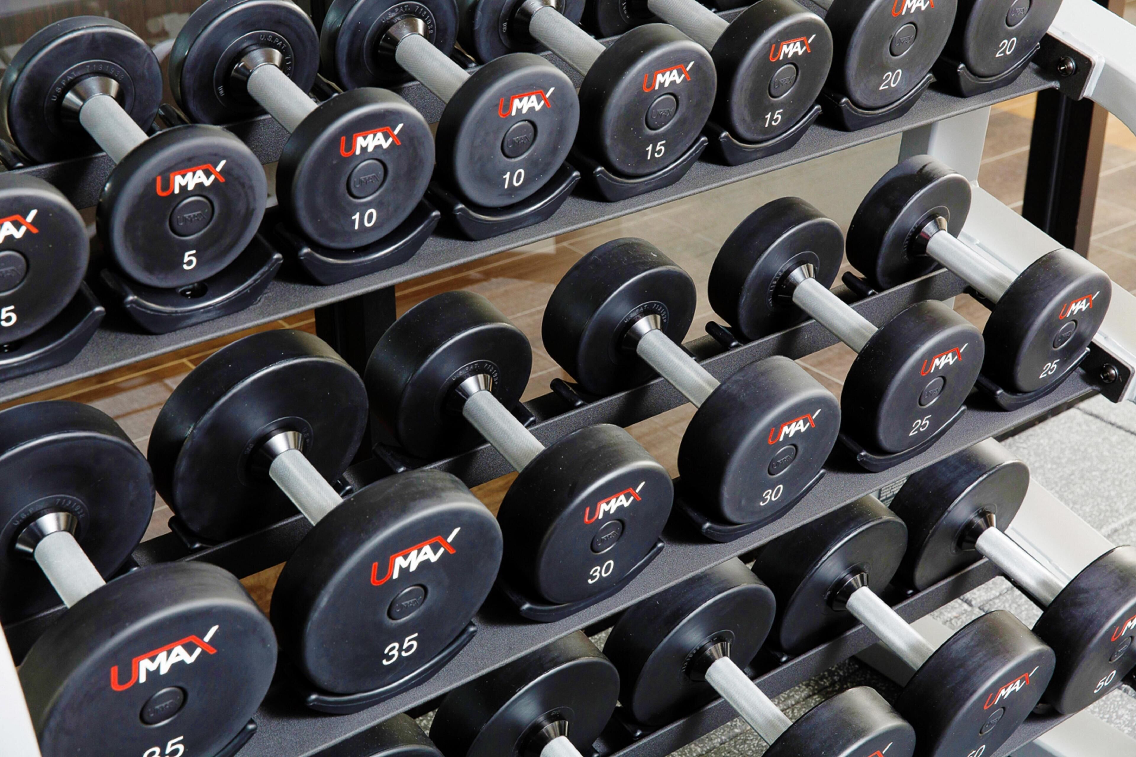 A rack of dumbbells with various weight markings.
